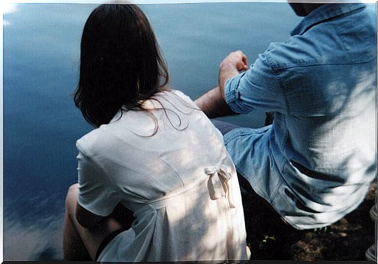 Couple sitting together by the water