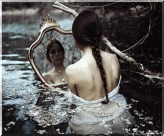 Woman in water looking in mirror