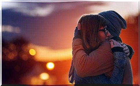 Two people hugging each other in front of a beautiful sunset is a nice picture of emotional expression.