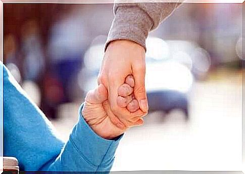 A person in a wheelchair holding hands with someone on their feet.