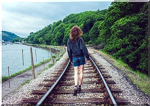 Woman walks along train track