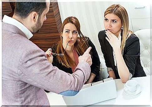 Male boss discusses with two female employees