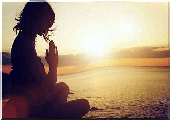 Woman meditating by the water