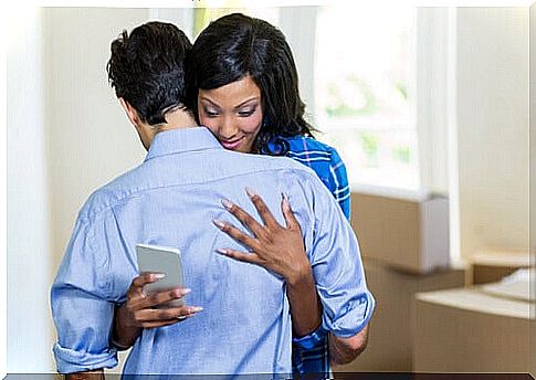 Woman is on the phone while giving a hug to a man