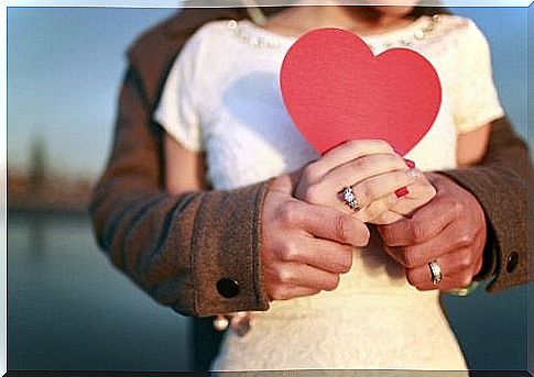 Couple holding a heart.