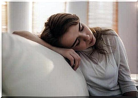 woman sitting on the couch and looking sad